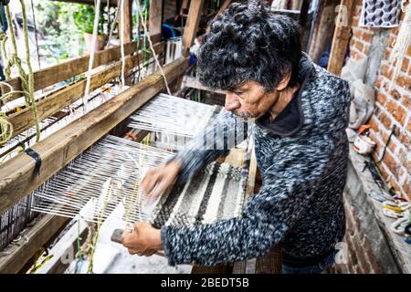 Ein Handwerker arbeitet den Webstuhl in einem Textilgeschäft in San Miguel de Allende in Mexiko. Stockfoto