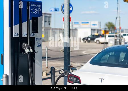 Ein Tesla Model 3 Elektroauto lädt die Batterien auf Stockfoto