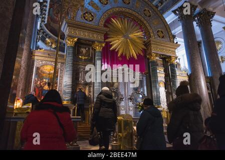Sankt Petersburg, Russland: Gläubige (nicht erkennbar) stehen in der Kasaner Kathedrale vor Ikonen in einer Reihe. Stockfoto