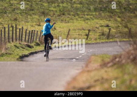 Cumbernauld, Großbritannien. April 2019. Im Bild: Ein Straßenradfahrer wird gesehen, wie er ein Selfie macht, während er während der Lockdown an einem hellen und heißen Ostermontag der Frühlingsfeiertage mit seinem Fahrrad fährt. Aufgrund der britischen und schottischen Absperrung des Coronavirus (COVID-19) hat die Polizei die Sperrung durchgesetzt und die Menschen haben die Warnung ernst genommen, da alle Touristen- und Schönheits-Hotspots mit Straßensperren abgesperrt wurden. Quelle: Colin Fisher/Alamy Live News Stockfoto