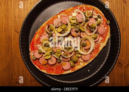Ansicht von oben von Bruschetta mit Hot Dog, Zwiebeln und Oliven Stockfoto