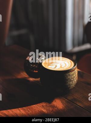 Heiße kunst Latte Kaffee in einer Tasse auf Holztisch. Stockfoto