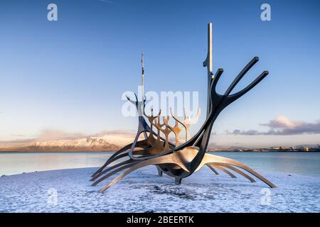 Bildunterschrift/Beschreibung: Reykjavik, Island. - 17. Januar 2020: Die SonnenVoyager, eine moderne Skulptur von Jon Gunnar Arnason, eines wikingerschiffes. Sonnenuntergang in Rey Stockfoto