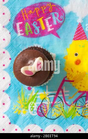 M&S Easter Cupcake auf Serviette Serviette Serviette - Mini-Schokolade Cupcakes mit Schokolade Buttercreme und Ostern Dekorationen - Osterhasen Ohren Stockfoto