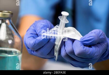 Krankenschwester öffnet eine neue Spritze in einem Krankenhaus, konzeptionelle Bild Stockfoto