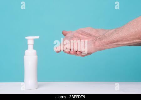 Alter Mann, der Alkoholgel zum Reinigen der Hände verwendet. Pandemieschutz, Hygienic and Health Care Konzept Stockfoto