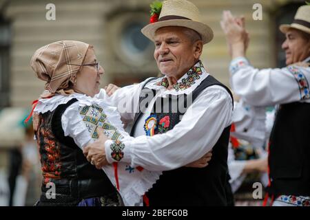 Bukarest, Rumänien - 5. März 2020: Ältere Frauen und Männer, in rumänischer traditioneller Kleidung gekleidet, tanzen auf einem Festival. Stockfoto