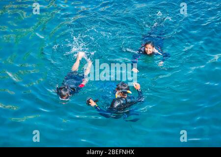 Pula, Kroatien - 31. Mai 2019: Gruppe von drei Personen, die im blauen Meerwasser mit Schnorchelmasken schwimmen Stockfoto