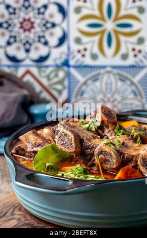 Rinderrippchen Bourguignonne in blauer Kasserolle. Hausgemachter Eintopf mit Gemüse und Rotwein. Stockfoto