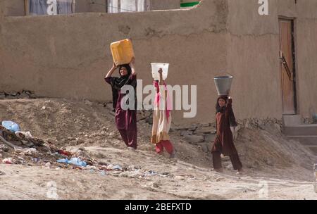 Kabul, Afghanistan - März 2004: Junge Frauen gehen mit Wasser nach Hause Stockfoto