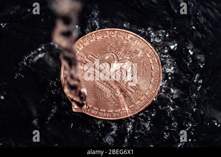 Bitcoin auf schwarzem Hintergrund. Bitcoin mit Wasser waschen. Stockfoto