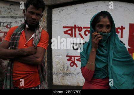 Dhaka, Bangladesch. April 2020. Eine Frau schaut zu, als ein Rikscha-Abzieher wartet, um wieder zurück zu kommen, als Polier ihre Rikschas in Dhaka ergriff. Die Regierung von Bangladesch hat eine Blockierung verhängt, um die Ausbreitung der durch das SARS-Cov-2-Coronavirus verursachten Pandemie COVID ''' 19 zu verlangsamen. Quelle: MD Mehedi Hasan/ZUMA Wire/Alamy Live News Stockfoto