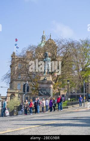 Edinburgh / Schottland / UK - 04/20/2014: Blick auf die Innenstadt von Edinburgh, Bronze-Statue der schwarzen Uhr Boer Kriegsdenkmal, Touristen, Bäume und ein öffentliches c Stockfoto