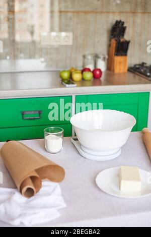Äpfel, Nudelholz, elektronische digitale Küchenwaage auf dem Tisch. Vorbereitung zum Kochen von Gebäck Stockfoto