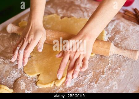 Hände arbeiten mit Teig Zubereitung Rezept Brot. Weibliche Hände und Teig für Pizza. Woman's Händen rollen den Teig. Mutter brötchen Teig auf die Küche Stockfoto