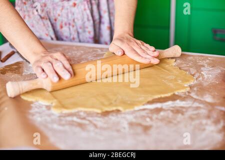 Hände arbeiten mit Teig Zubereitung Rezept Brot. Weibliche Hände und Teig für Pizza. Woman's Händen rollen den Teig. Mutter brötchen Teig auf die Küche Stockfoto