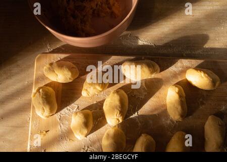 Kartoffelkuchen mit Kohl vor dem Backen auf einem Schneidebrett. Stockfoto