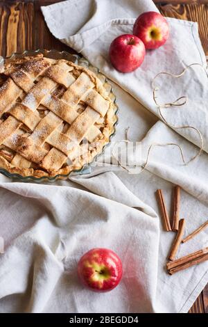 Hausgemachter Apfelkuchen auf dem braunen Holztisch. Apfeltarte mit Gitter oben Ansicht von oben. Rustikaler Stil Stockfoto
