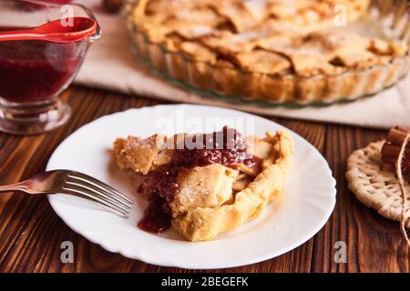 Apfelkuchen auf buntem Teller mit Gabel und Marmelade. Nahaufnahme Stockfoto