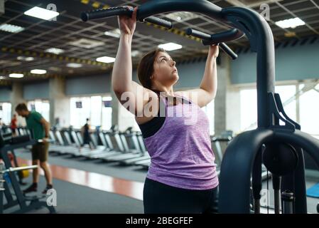 Übergewichtige Frau auf dem Trainingsgerät im Fitnessstudio Stockfoto