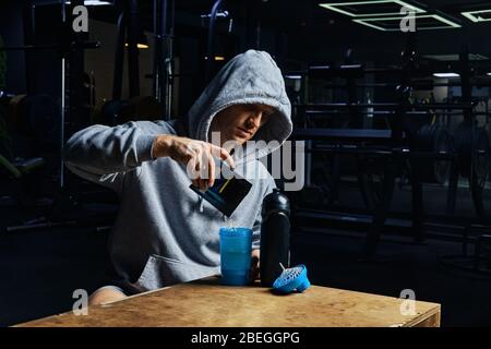 Mann gießt Energie Sport Ergänzung in der Flasche Stockfoto