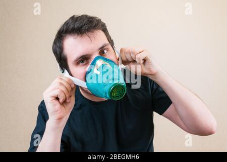 Junger Mann in Schutzmaske während der Selbstisolierung und Quarantäne. Bleib zu Hause Stockfoto