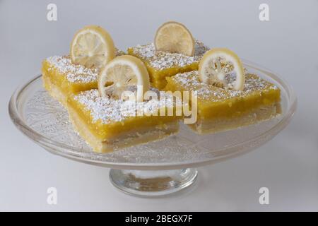 Hausgemachte gebackene Zitronenriegel mit geschnittenen Zitronen und Puderzucker gekrönt Stockfoto