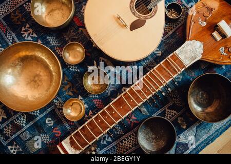 Traditionelle Instrumente: Sitar und portugiesische Gitarre und Klangschalen Stockfoto