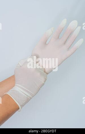 Hände für Frauen, die Latexhandschuhe anziehen Stockfoto