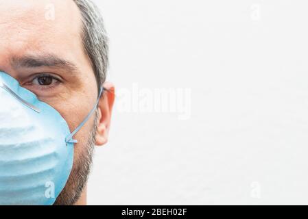 Nahaufnahme eines müden Mannes mit einer medizinischen Maske auf weißem Hintergrund. Platz für Text kopieren Stockfoto