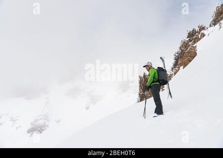 Skifahrer stehen oben auf der Linie mit Blick auf die nebligen Berge Stockfoto