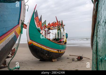 Männer auf einem mondförmigen Fischerboot in einem Fischerdorf südlich von Cox's Bazar Stockfoto