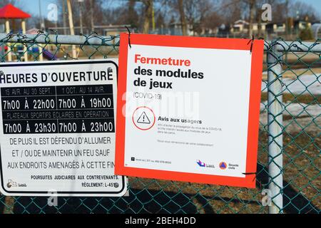 Schild in Französisch Warnung, dass ein Kinderspielplatz wegen Covid-19 geschlossen ist. Laval, Provinz Quebec, Kanada. Stockfoto