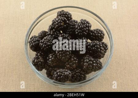 Frische rohe Brombeeren in Glas Obstschale auf brauner Tischdecke Stockfoto