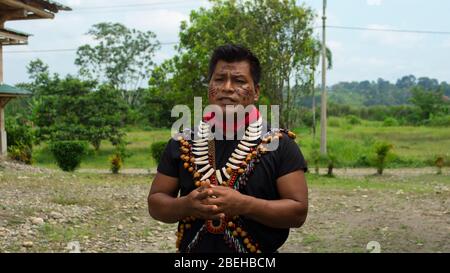 Lago Agrio, Sucumbios / Ecuador - Februar 20 2020: Cofan Ethno-Mann spricht in traditioneller Kleidung in der Cofan Dureno Jahrtausend-Gemeinde Stockfoto