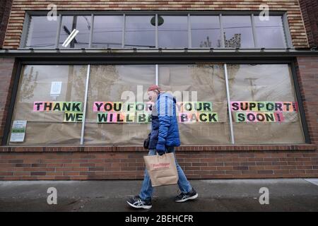 Portland, USA. April 2020. Am 1. April 2020 geht ein Mann an einer Nachricht im Fenster eines Einzelhändlers in Portland, Oregon, vorbei. (Foto: Alex Milan Tracy/Sipa USA) Quelle: SIPA USA/Alamy Live News Stockfoto