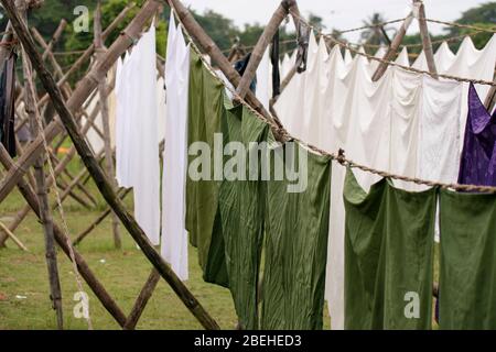 Grüne und weiße Wäsche, die in der Sonne im Dhobi Khana in Kochi (Cochin), Kerela, Indien, zum Trocknen aufgehängt wird Stockfoto