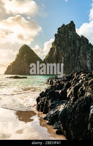 Schöner Sonnenuntergang am Strand Cacimba do Padre mit Blick auf den Dois Irmaos Hügel und türkisblaues Wasser, bei Fernando de Noronha, UNESCO-Weltkulturerbe Stockfoto