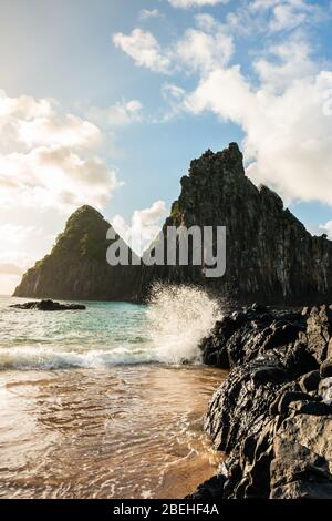 Schöner Sonnenuntergang am Strand Cacimba do Padre mit Blick auf den Dois Irmaos Hügel und türkisblaues Wasser, bei Fernando de Noronha, UNESCO-Weltkulturerbe Stockfoto