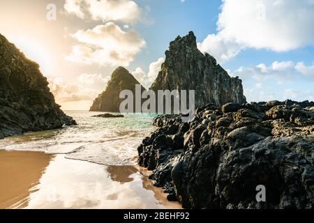 Schöner Sonnenuntergang am Strand Cacimba do Padre mit Blick auf den Dois Irmaos Hügel und türkisblaues Wasser, bei Fernando de Noronha, UNESCO-Weltkulturerbe Stockfoto