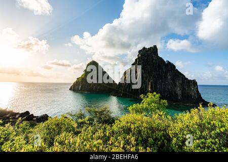 Schöner Sonnenuntergang am Strand Cacimba do Padre mit Blick auf den Dois Irmaos Hügel und türkisblaues Wasser, bei Fernando de Noronha, UNESCO-Weltkulturerbe Stockfoto