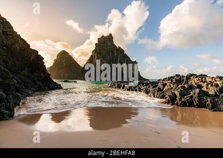 Schöner Sonnenuntergang am Strand Cacimba do Padre mit Blick auf den Dois Irmaos Hügel und türkisblaues Wasser, bei Fernando de Noronha, UNESCO-Weltkulturerbe Stockfoto