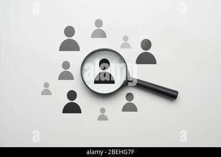 Mitarbeitersuche HR-Konzept - Lupe mit abstraktem Mitarbeiter auf weißem Hintergrund. Nahaufnahme. Stockfoto