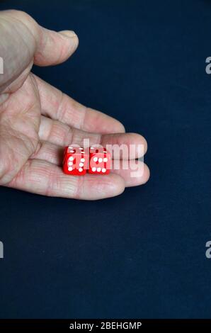 Eine offene Hand mit zwei roten Würfeln, wobei beide sechs zeigen. Stockfoto