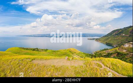 Antenne: Toba-See und die Insel Samosir Blick von oben Sumatra Indonesien. Riesige vulkanische Caldera von Wasser bedeckt, traditionelle Batak Dörfer, grüne Reis Stockfoto