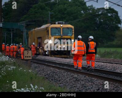 Schottermaschine mit Eisenbahnunternehmen für Network Rail Verpacken von Ballast unter neuer Gleise bei Brock, nördlich von Preston an der Westküste Stockfoto