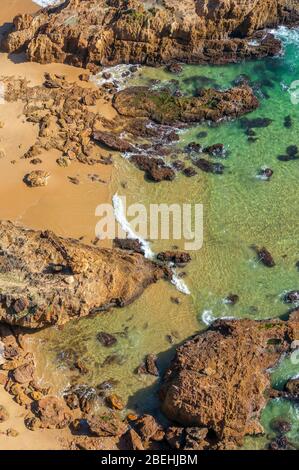 Blick von oben auf unberührten tropischen Strand mit malerischen Klippen und Felsen, transparentem Wasser und gelbem Sand. Sommer Badeurlaub, Fernweh b Stockfoto