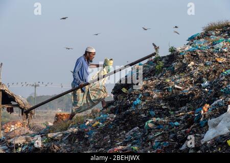 Mann mit Stock und Tasche Müllsortierung in einem Mülldep bei Sylhet, Bangladesch Stockfoto