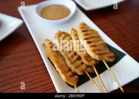 Schweinefleisch Satay Spieße mit dicken Erdnuss Dipping Sauce serviert Stockfoto