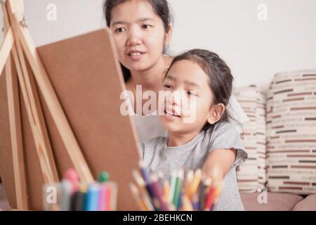 Mutter und Tochter teilen ihre Ferien. Kinder lernen Malen mit Eltern. Stockfoto